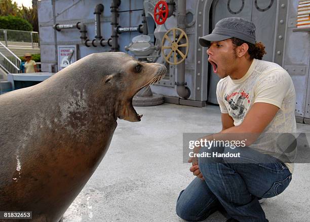 In this handout photo provided by SeaWorld San Diego, Corbin Bleu, of "High School Musical", poses with Clyde the sea lion at SeaWorld San Diego on...