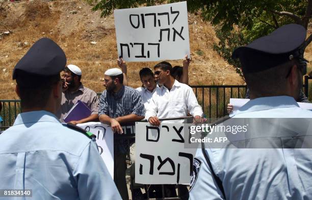 Israeli right-wingers hold signs reading in Hebrew : ?Destroy the house? during a demonstration calling for the demolition of the family house of...