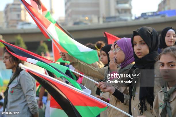 Lebanese and Palestinian people hold flags as they stage a demonstration to protest the Israeli violations and restrictions against the Al-Aqsa...