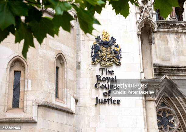 Exterior view of the Royal Courts of Justice building on the Strand in London with the royal coat of arms and signage. The Royal Courts of Justice...