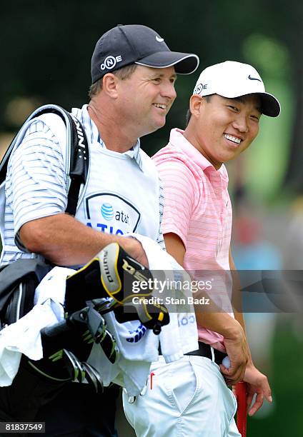 Caddie Eric Larson and Anthony Kim wait for play at the second tee box during the final round of the AT&T National held on the Blue Golf Course at...