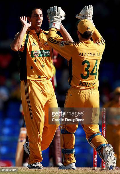 Mitchell Johnson of Australia celebrates with wicketkeeper Luke Ronchi after dismissing Daren Powell of West Indies during the One-Day International...