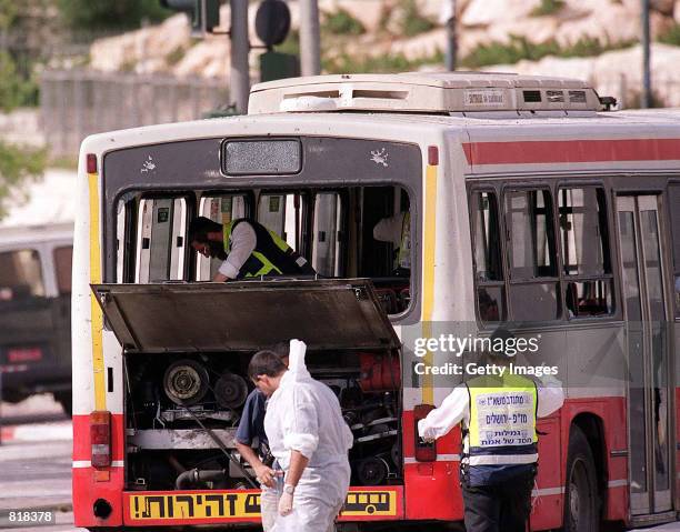 Israeli bomb disposal personnel and police look at a bus that was hit by a suicide bomber March 27, 2001 in Jerusalem. The explosion killed one...