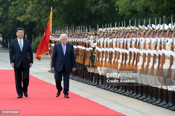 Palestinian President Mahmoud Abbas and President of China Xi Jinping walk past the honor guards during an official welcoming ceremony in Beijing,...