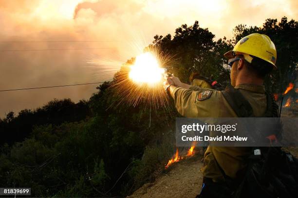 Firefighter shoots a flare gun into the brush as U.S. Forest Service Hot Shots set a backfire to try to contain the Gap fire, officially the top...