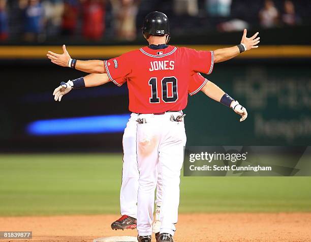 Chipper Jones of the Atlanta Braves congratulates Mark Teixeira after knocking in the winning run in the 17th inning against the Houston Astros at...