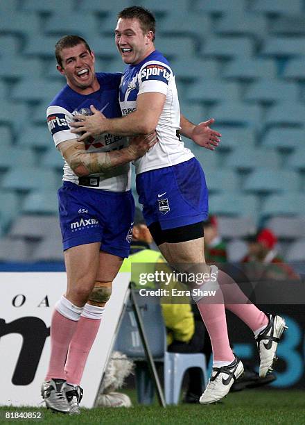 Andrew Ryan of the Bulldogs congratulates team-mate Brent Crisp after he scored a try during the round 17 NRL match between the Bulldogs and the...