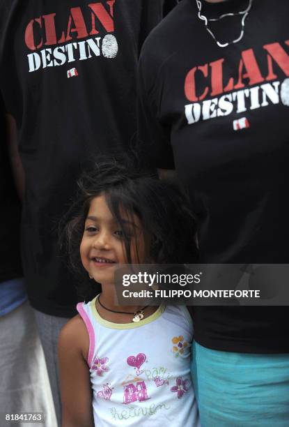 Rom girl stands by humanitarian group wareing T-shirts reading "Clandestine" following a meeting in the Rom camp on the outskirts of Rome on July 7,...