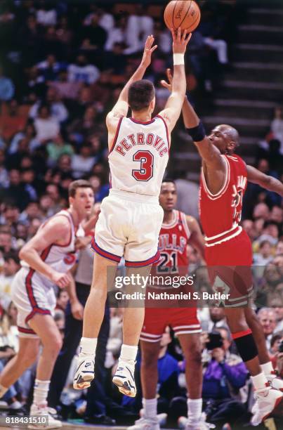 Drazen Petrovic of the New Jersey Nets shoots against Michael Jordan of the Chicago Bulls at the Brendan Byrne Arena in East Rutherford, NJ circa...