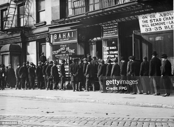 Unemployed men queuing for coffee and bread at a soup kitchen run by the Bahai Fellowship at 203 East 9th Street, New York, circa 1930.