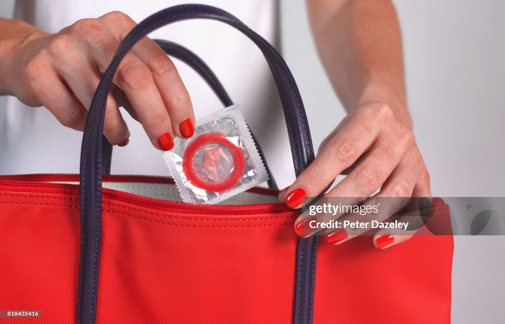 Strawberry condom in handbag