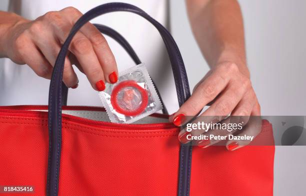 strawberry condom in handbag - condom stock pictures, royalty-free photos & images