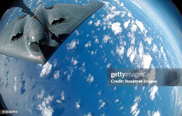 a kc-135 stratotanker refuels a b-2 spirit. - rotor basculante fotografías e imágenes de stock