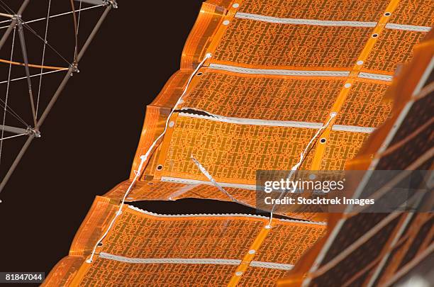 close-up view of a repaired solar array on the international space station. - iss window stock pictures, royalty-free photos & images