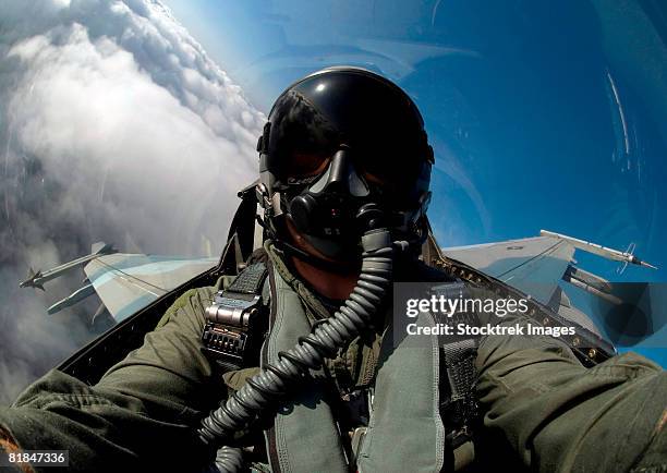 a pilot flying a f-16 fighting falcon. - avion de chasse photos et images de collection