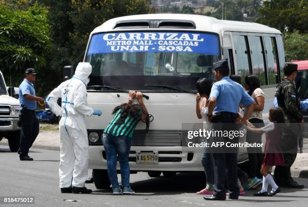 Relative of a bus driver killed by gang members for refusing to pay them a "war tax", cries next to the minibus, in Tegucigalpa on July 18, 2017....