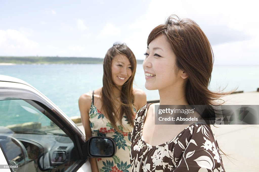 Young women resting outside of car