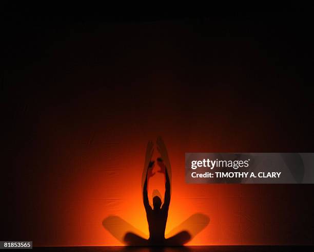 Using a rear-projection screen to display their dance movements, the modern dance group Pilobolus perform "Darkness and Light" during a dress...