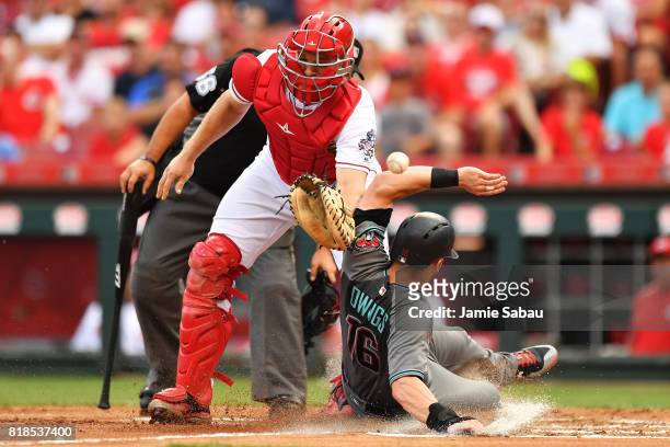 Chris Owings of the Arizona Diamondbacks slides home safely in the second inning as catcher Stuart Turner of the Cincinnati Reds misses the throw at...