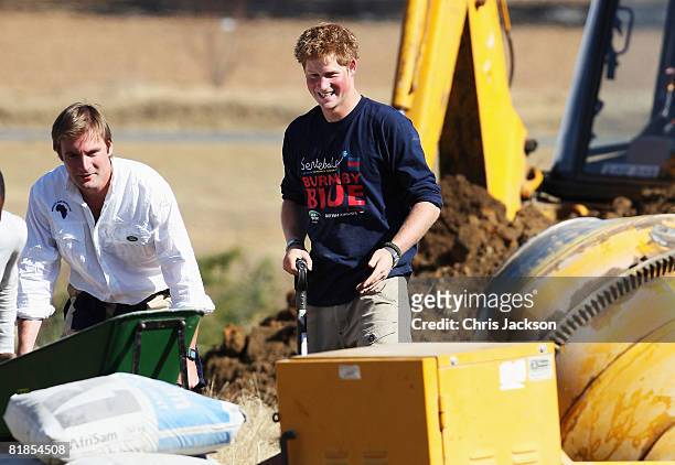 Prince Harry smiles as he helps rebuild a school on July 8, 2008 in Buthe Buthe, Lesotho. Prince Harry and 26 soldiers from the Household Cavalry are...