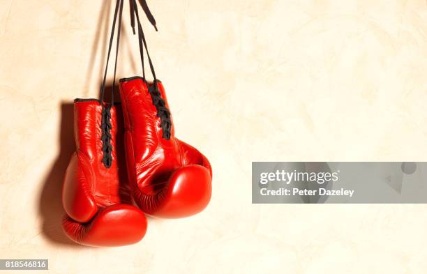 red boxing gloves with copy space - boxing glove coloured background stock pictures, royalty-free photos & images