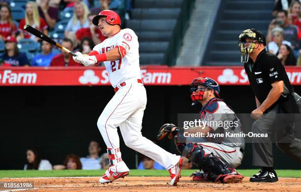 Umpire Jeff Nelson and Chris Heisey of the Washington Nationals look on as Mike Trout of the Los Angeles Angels of Anaheim hits a solo home run in...