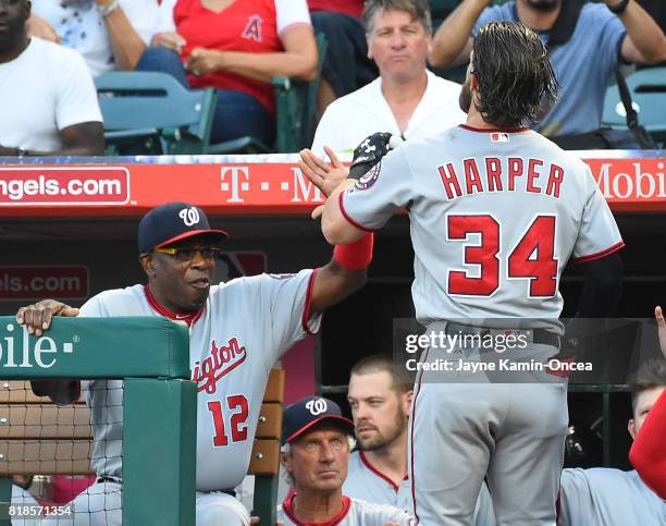 Bryce Harper of the Washington Nationals is greeted by Dusty Baker at the dugout after hitting a solo home run in the first inning of the game...