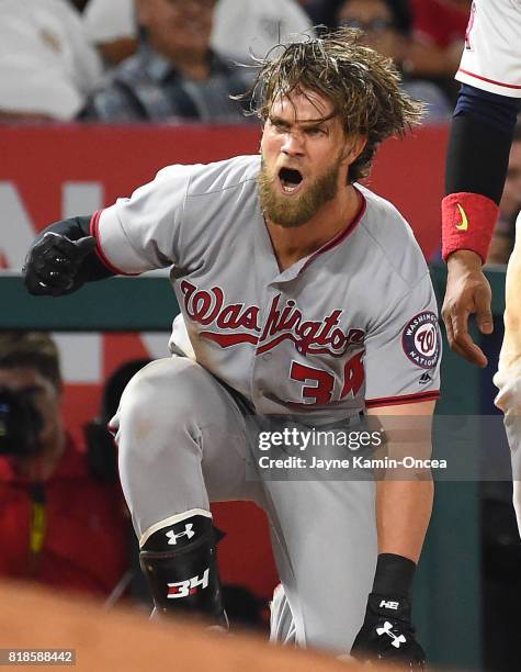 Bryce Harper of the Washington Nationals reacts after he beats the throw to Yunel Escobar of the Los Angeles Angels of Anaheim for a triple in the...