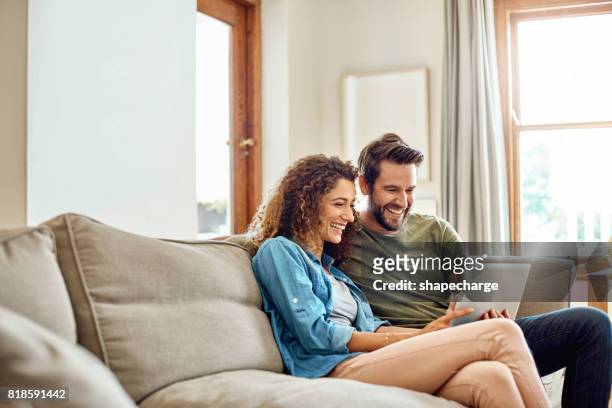 happiness is being connected to the home wifi - couple sofa stock pictures, royalty-free photos & images