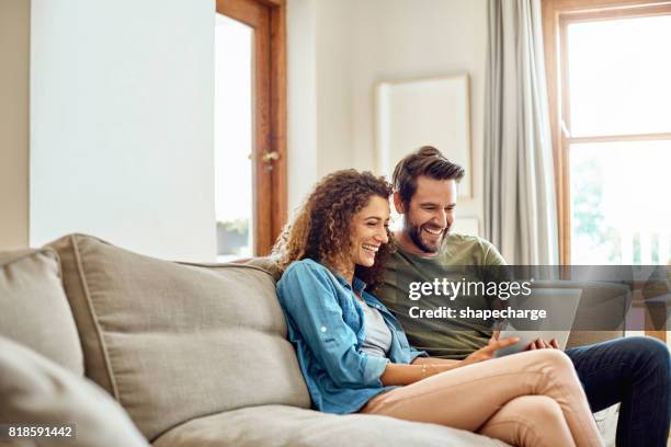 happiness is being connected to the home wifi - young couple imagens e fotografias de stock