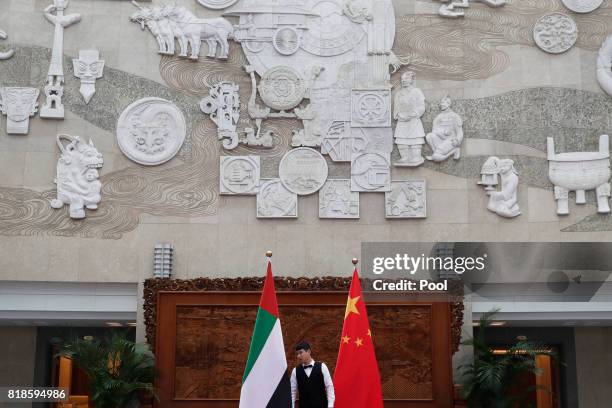 Worker checks on the United Arab Emirates and China national flags for a bilateral meeting between UAE's minister of state Sultan Ahmed Al Jaber and...