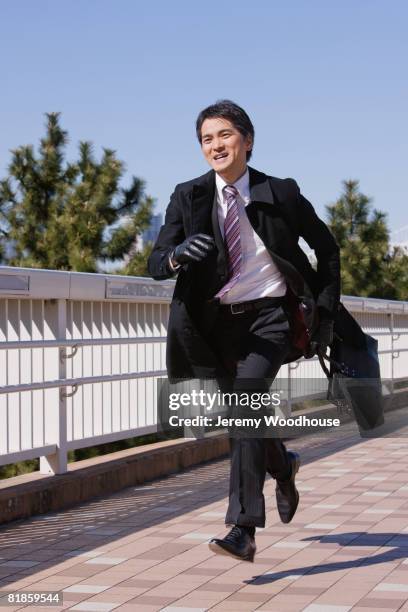 asian businessman running with briefcase - businessman running stock pictures, royalty-free photos & images