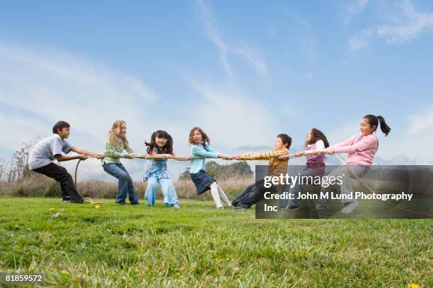 multi-ethnic children playing tug-of-war - asian games day 9 stock-fotos und bilder