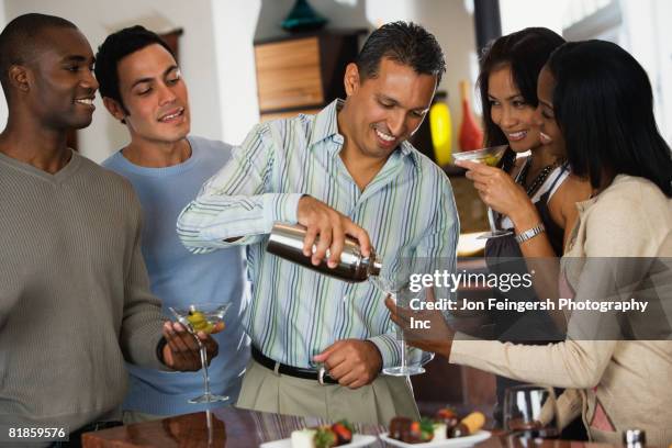 hispanic man pouring drink at party - cocktail shaker stock pictures, royalty-free photos & images