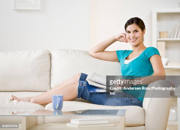 hispanic woman sitting on sofa - coffee table reading mug stock pictures, royalty-free photos & images