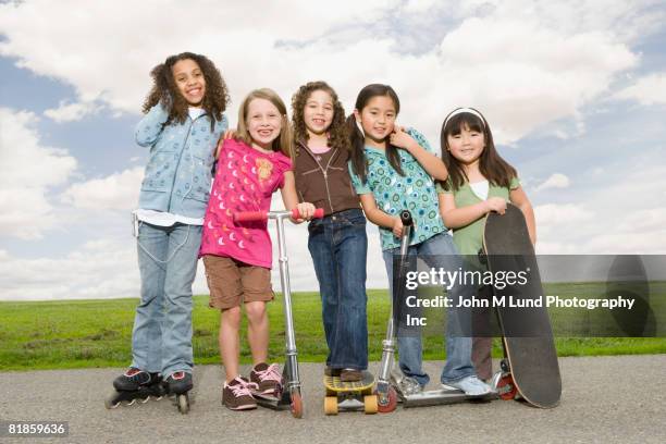 multi-ethnic girls on roller skates, scooters and skateboards - roller skates stock-fotos und bilder