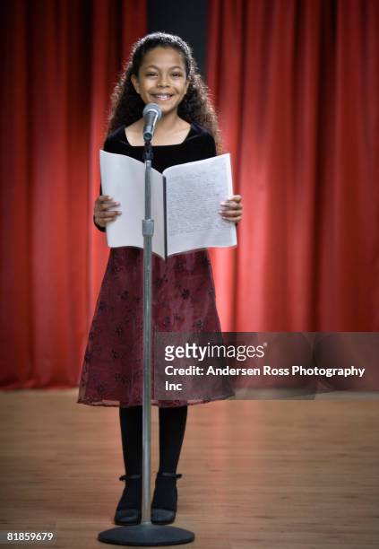 mixed race girl reading on stage - girl stage stock-fotos und bilder