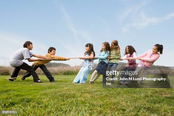multi-ethnic children playing tug-of-war - lucha de la cuerda fotografías e imágenes de stock