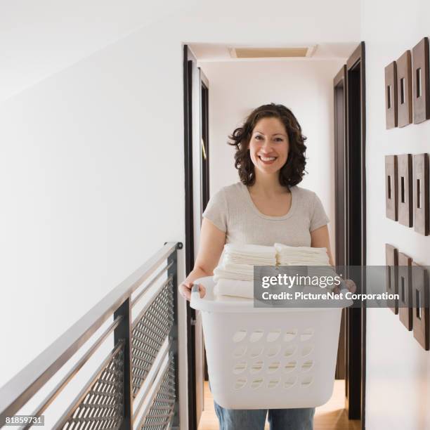 hispanic woman carrying laundry basket - laundry basket stock pictures, royalty-free photos & images