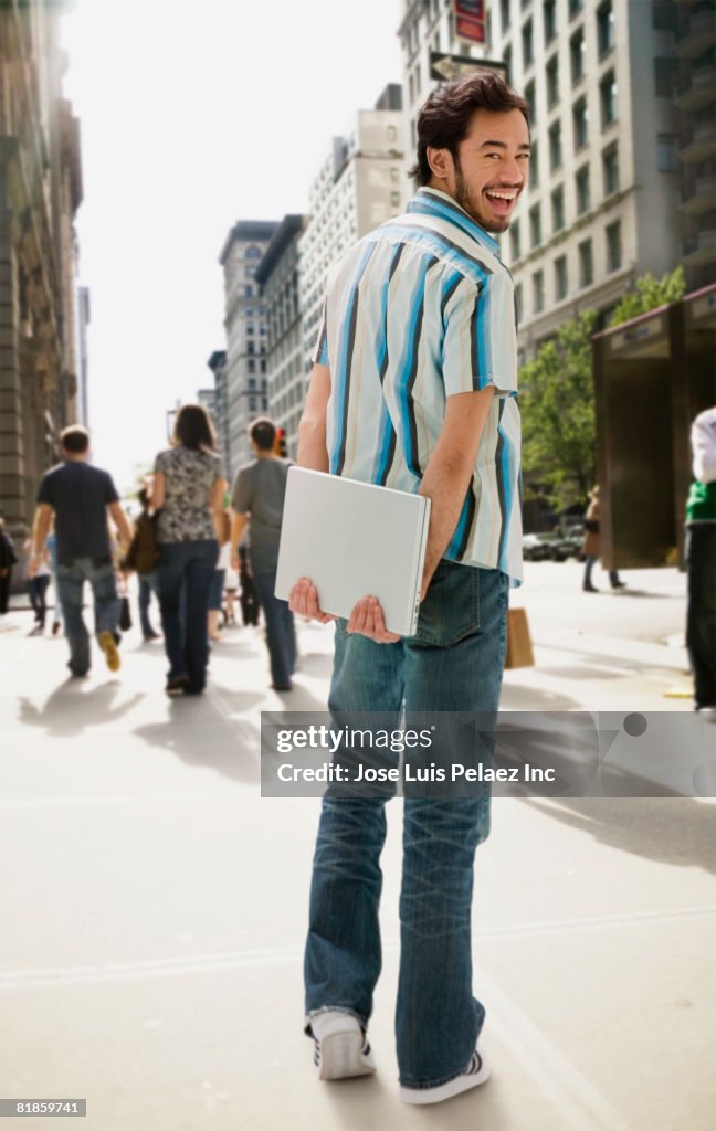 Asian man carrying laptop