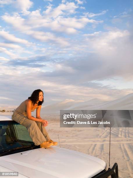 mixed race woman sitting on top of truck - sitting on top of car stock pictures, royalty-free photos & images