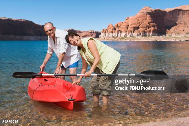 multi-ethnic senior couple next to kayak in water - northern european descent ストックフォトと画像