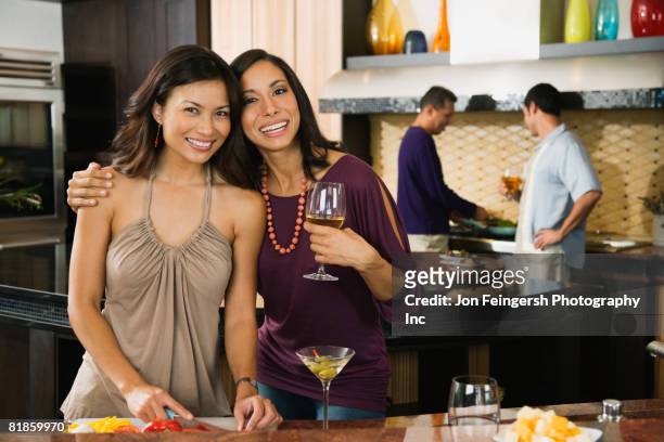 multi-ethnic women hugging at party - cocktail party work stock pictures, royalty-free photos & images