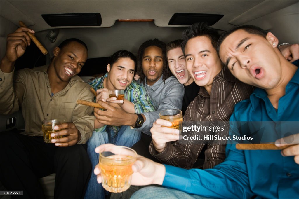 Multi-ethnic men celebrating in limousine