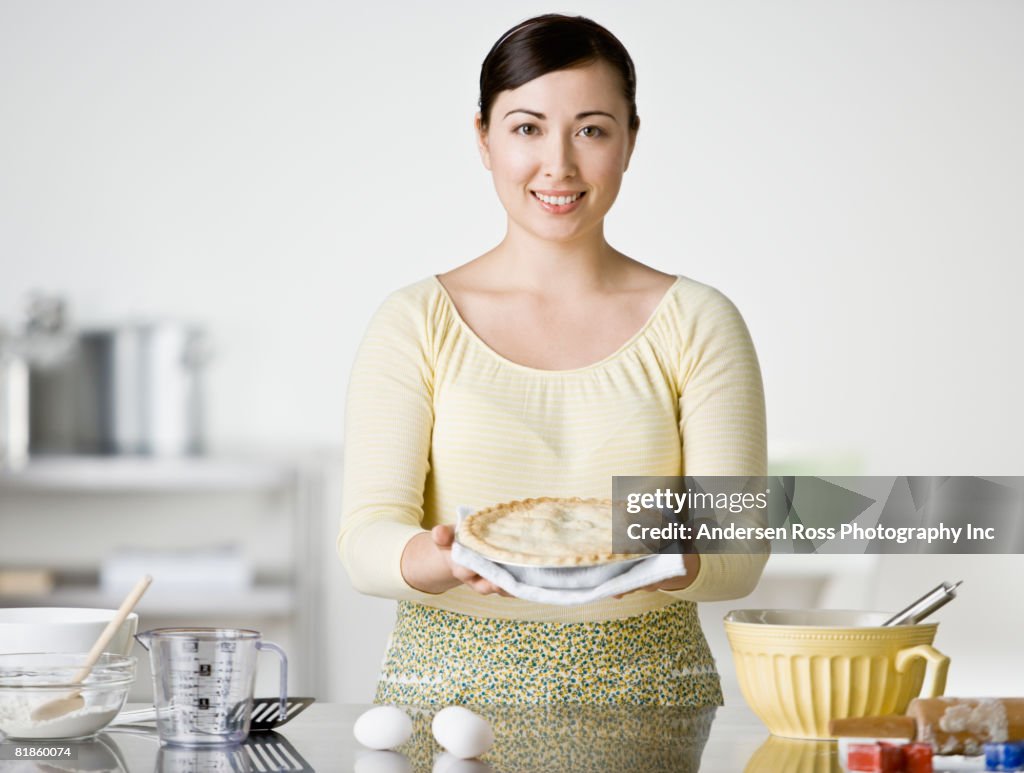 Asian woman holding homemade pie