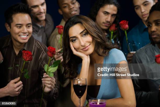 multi-ethnic men giving roses to woman - seduzione foto e immagini stock