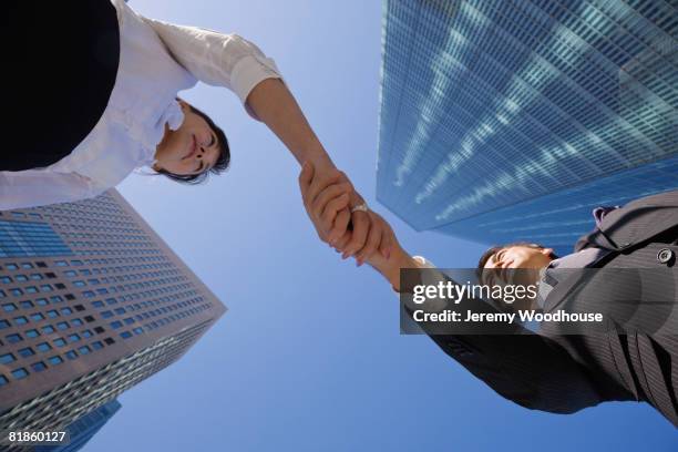 asian businesspeople shaking hands - japanese bussiness woman looking up imagens e fotografias de stock