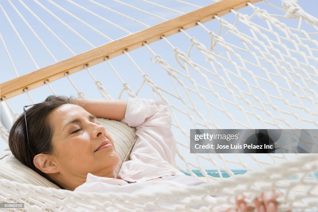 Hispanic woman laying in hammock