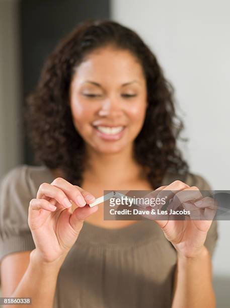 mixed race woman breaking cigarette - quitting smoking stock pictures, royalty-free photos & images
