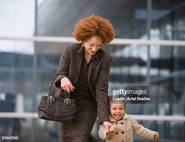 african mother holding daughter?s hand - working mother ストックフォトと画像